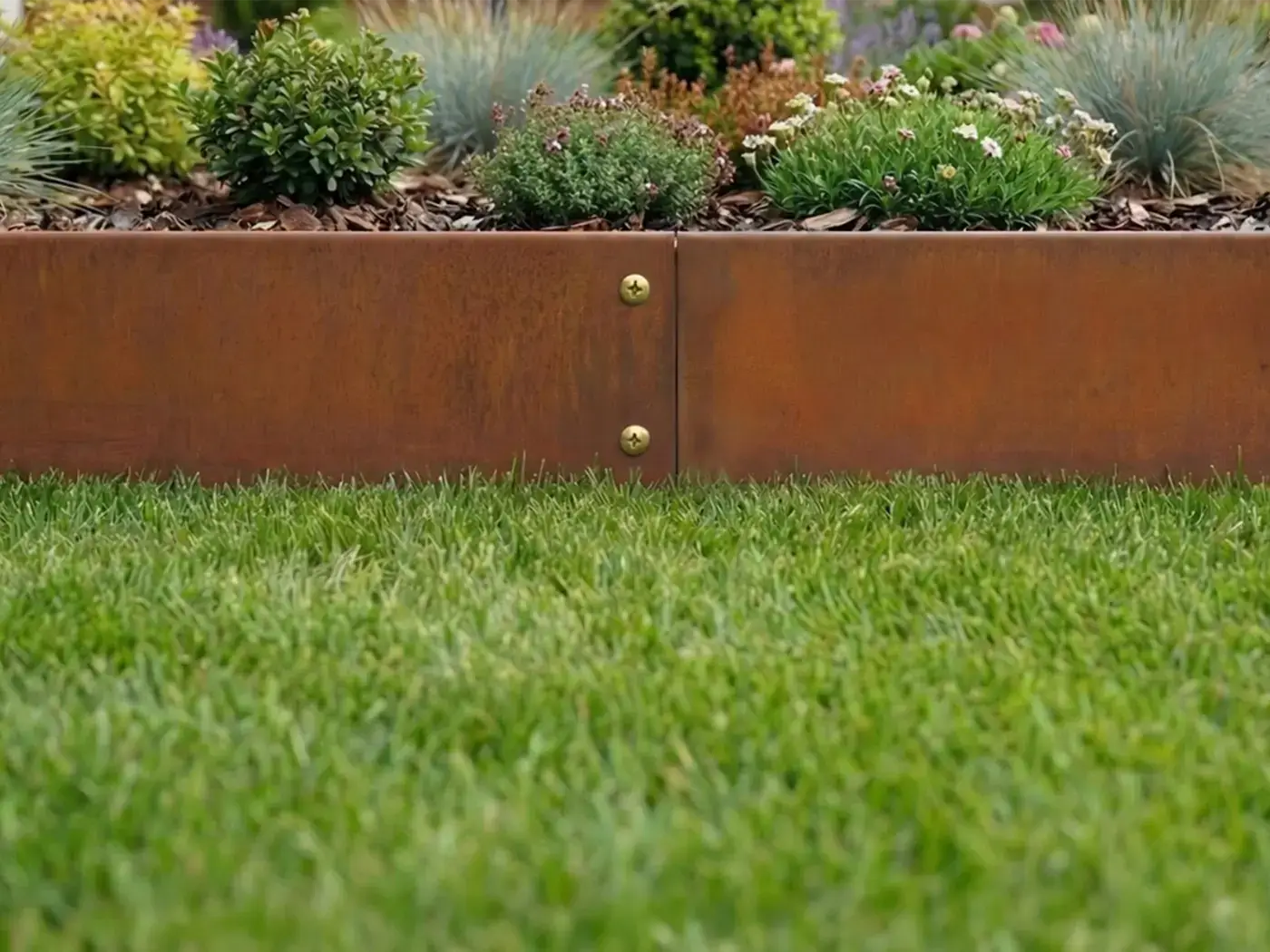 Detailaufnahme Rasenkante aus Cortenstahl mit Schraubverbindung und kindericherer abgerundeter Kante