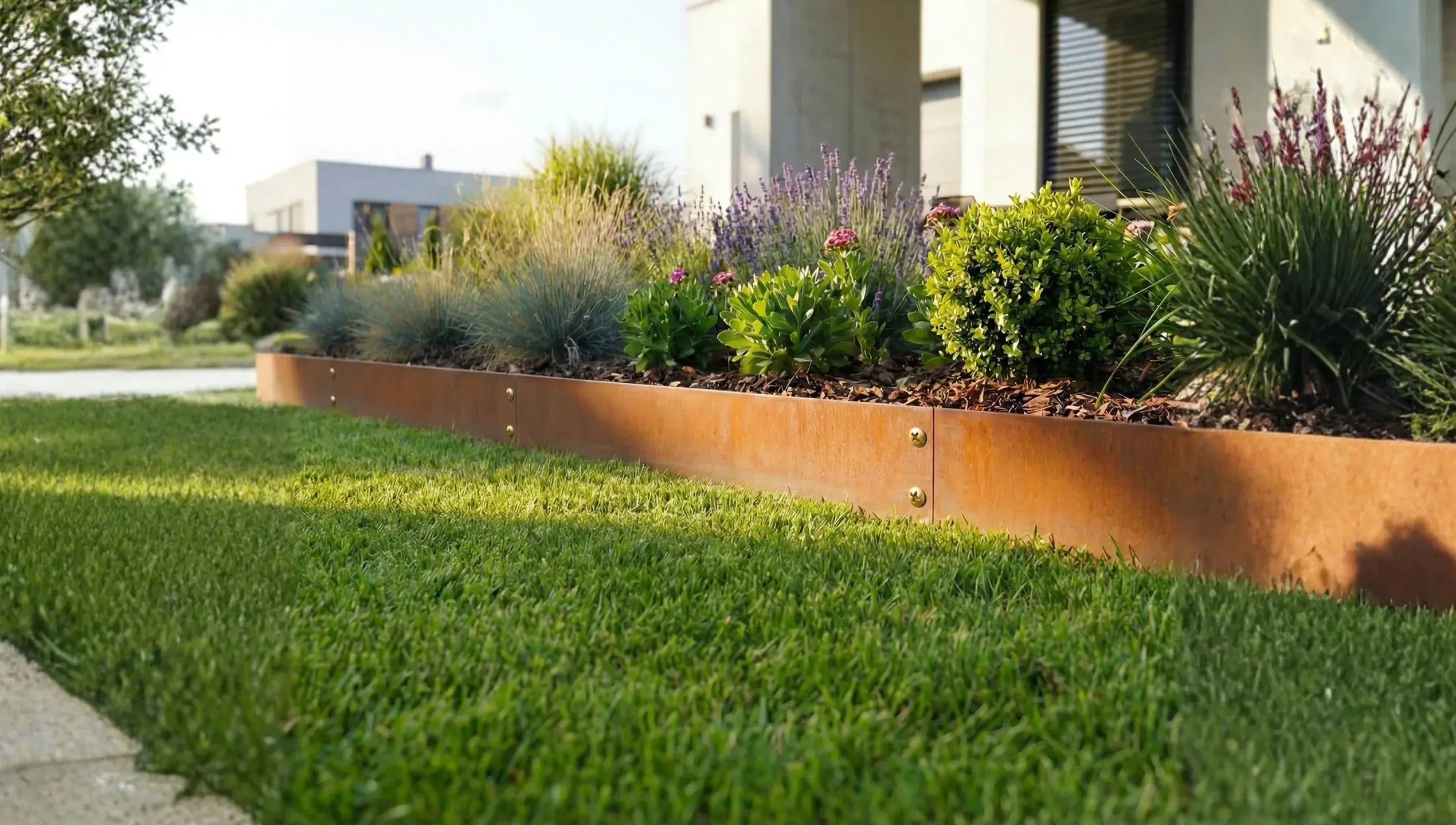 Cortenstahl Rasenkanten  als geradlinige verschraubte Beeteinfassung zwischen Rasen und Terrasse